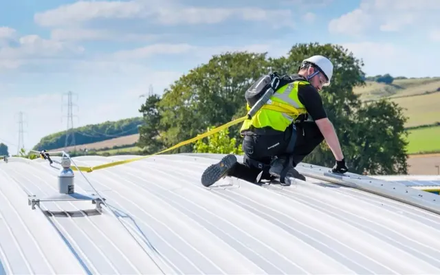 Operative clipped to a Latchways Constant Force post lifeline on a profiled metal roof