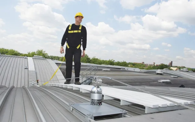 Operative on a rooftop walkway clipped to a Latchways post